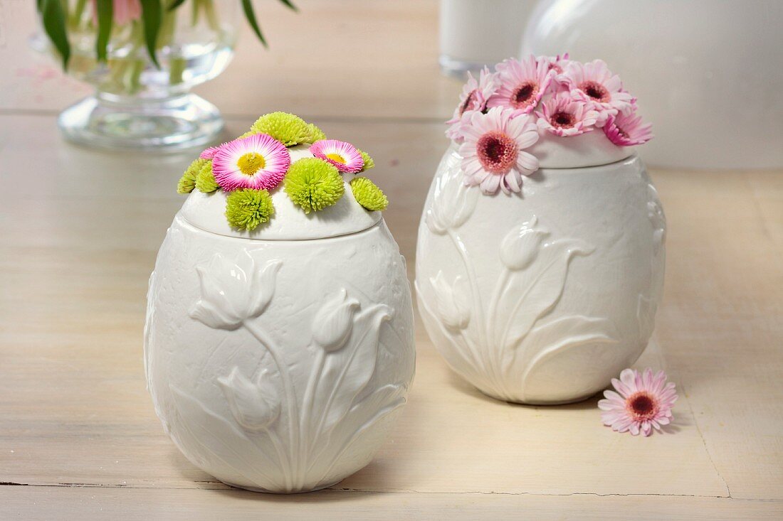weiße Porzellandosen in Eiform mit Frühlingsblüten österlich dekoriert