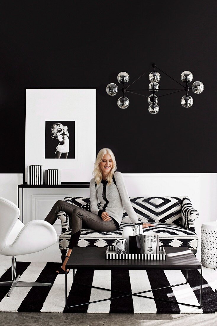 Junge Frau in einem schwarz-weißen Wohnzimmer mit grafischen Mustern