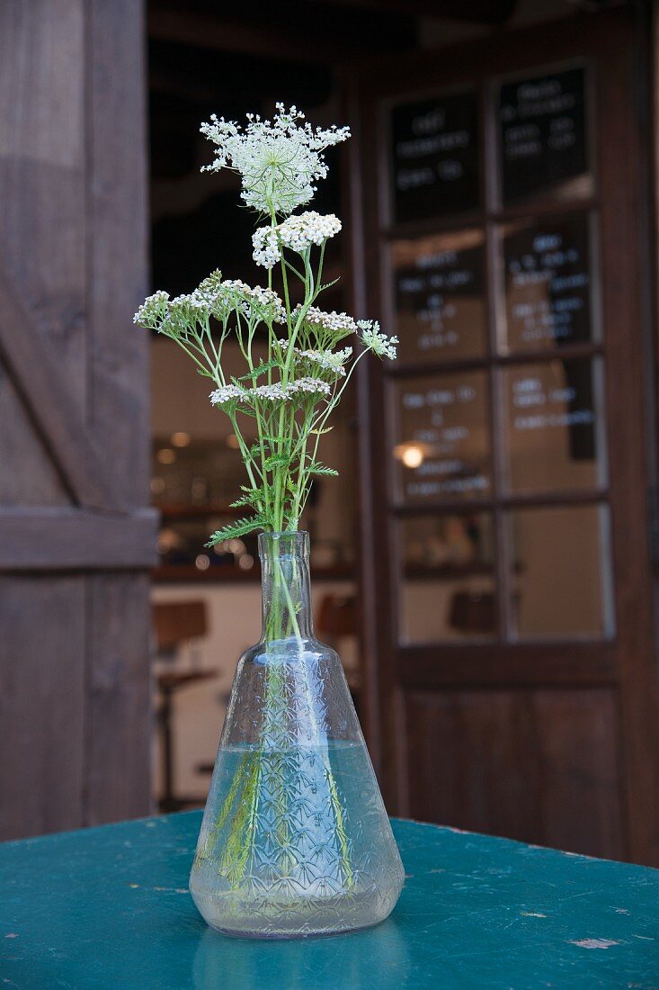 White wildflowers in vintage glass vase