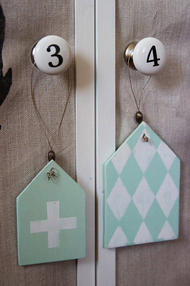 Shabby chic pendants with diamond and cross motifs hung from furniture knobs