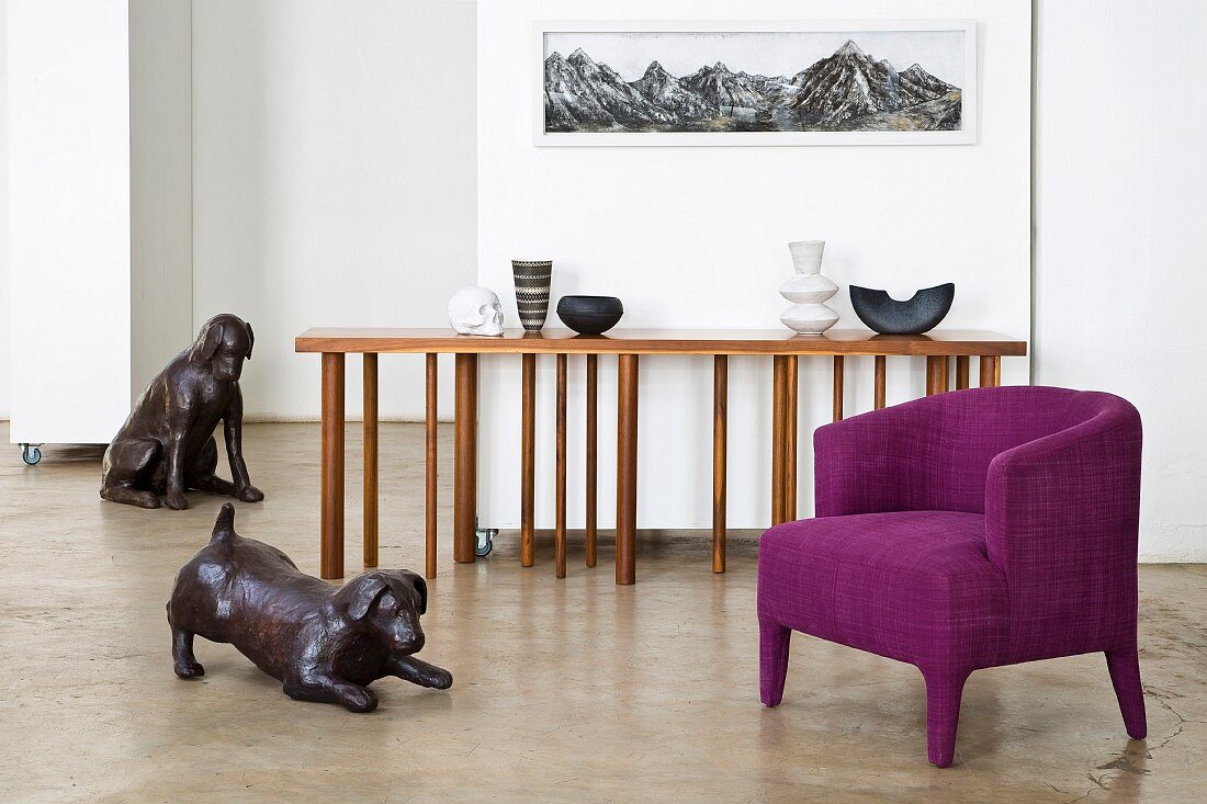 Tierskulpturen aus Bronze in modernem Wohnraumambiente mit violettem Sessel und Designer-Konsolentisch