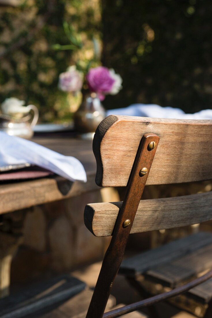 Rustikaler Holztisch und Stuhl im Gastgarten eines Restaurants