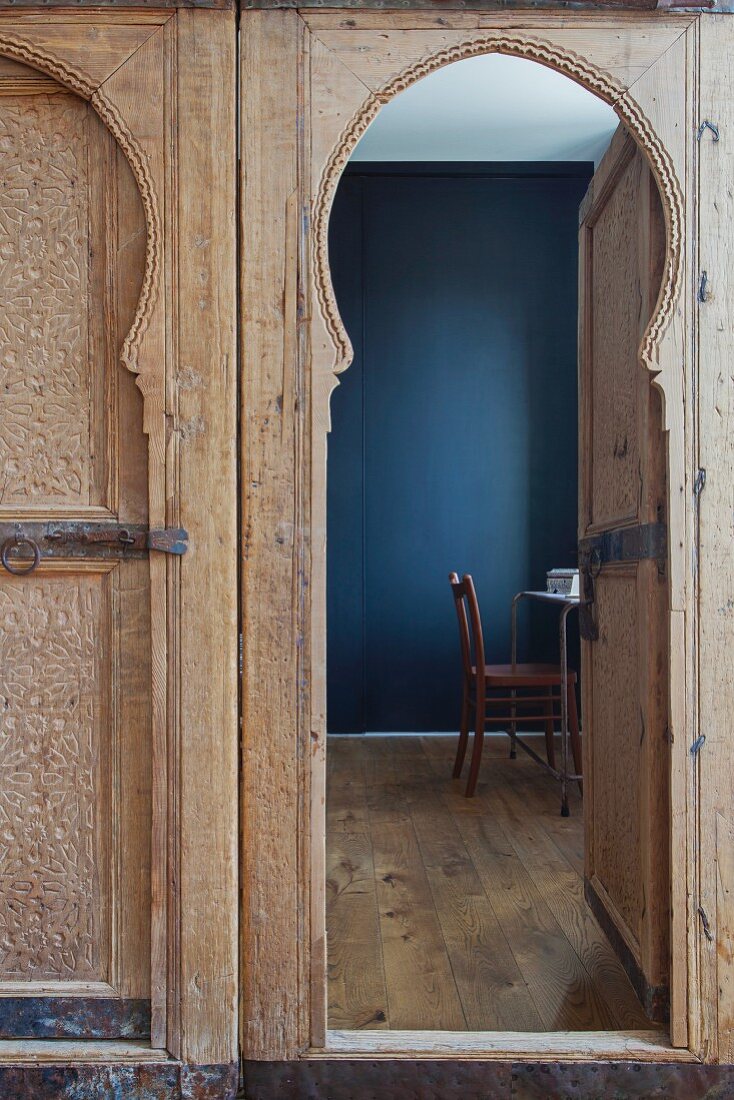 Blick durch offene, marokkanische Holztür auf Schreibplatz