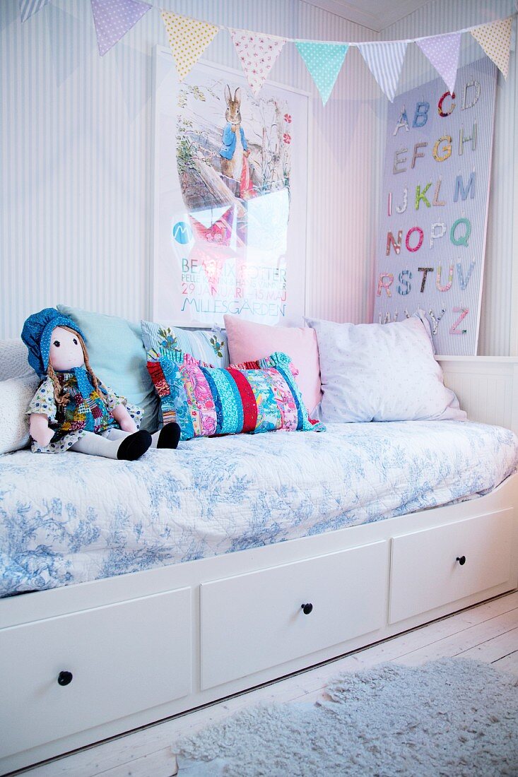 Kinderzimmer in Pastelltönen mit Wimpelkette über dem Bett