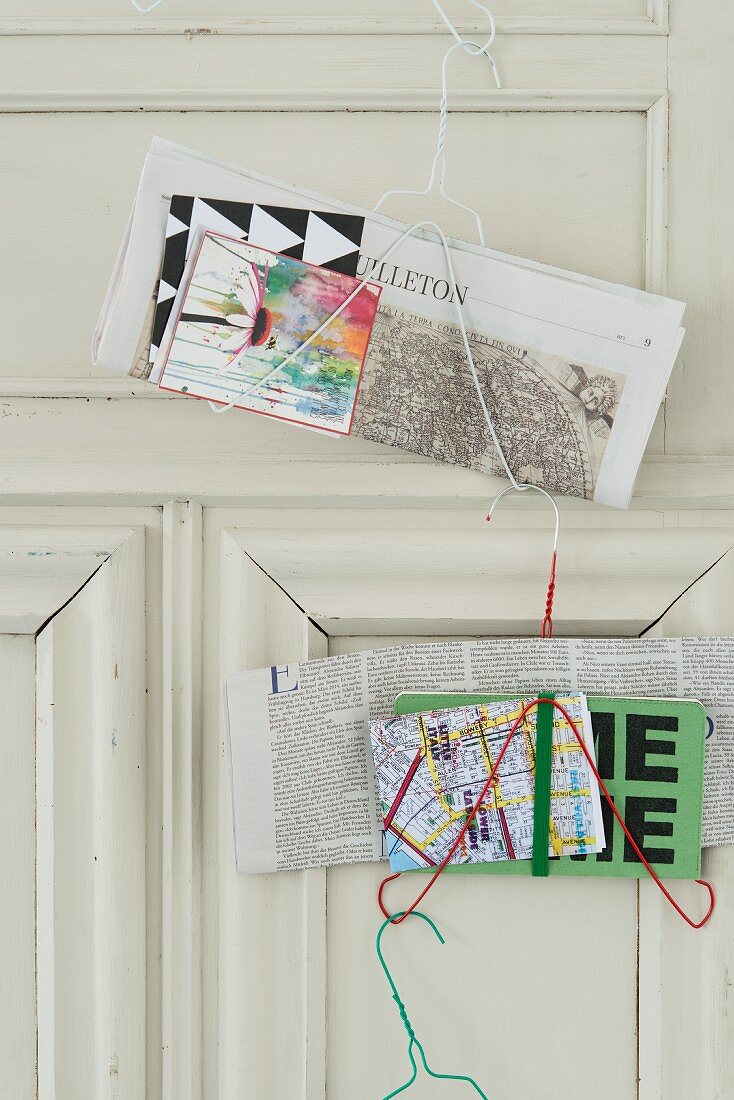 Newspaper holders made from wire coat hangers on the back of a door