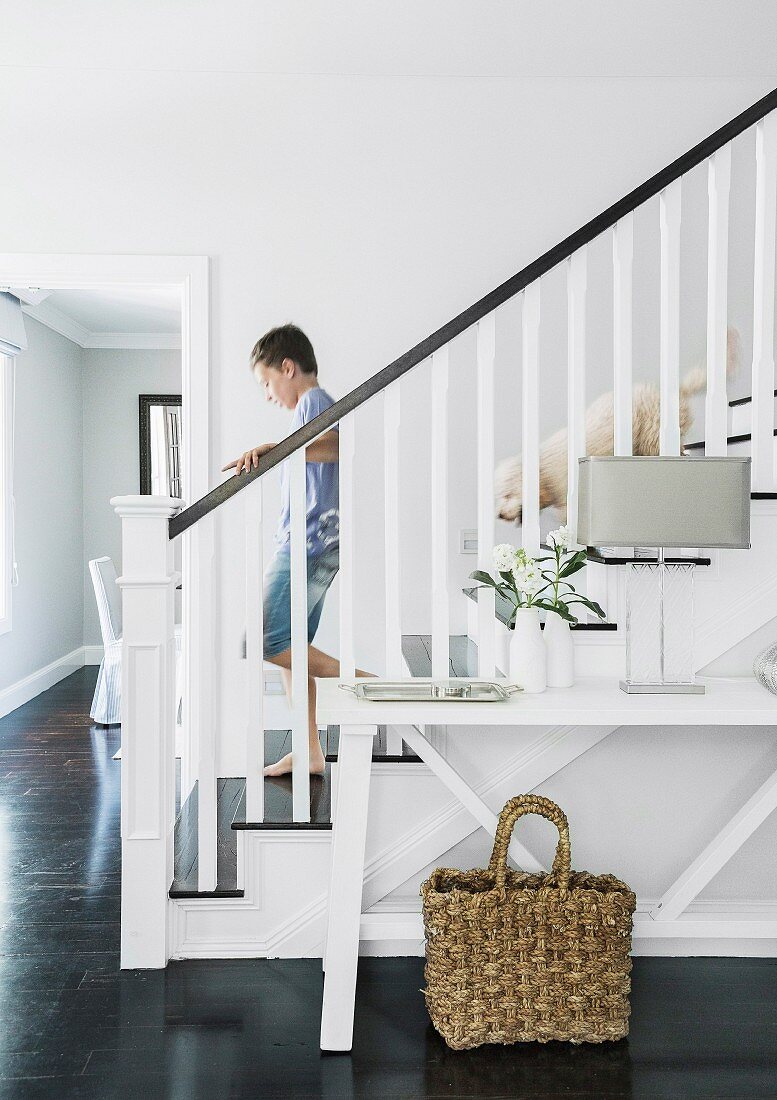 Weiß lackierte Holztreppe mit Jungem und Hund in elegantem Landhaus-Treppenhaus