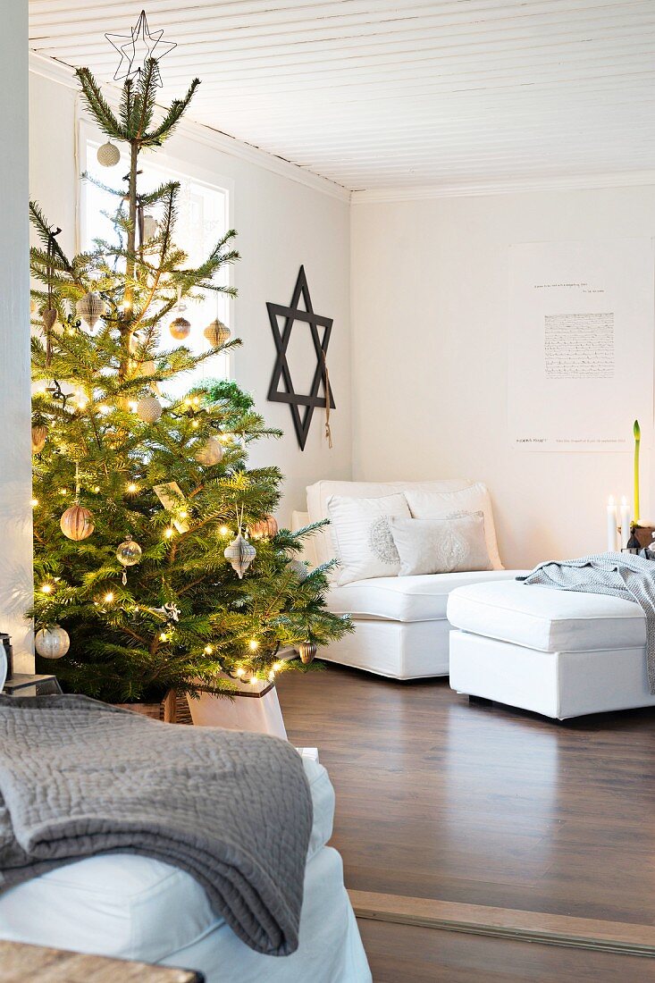 Beleuchteter Weihnachtsbaum im Wohnzimmer mit Davidstern