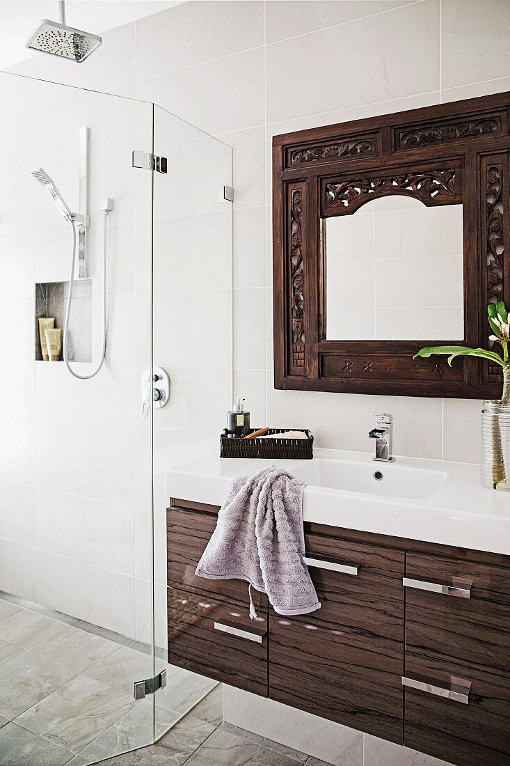 Waschtischmöbel mit modernem Schubladenunterschrank, Wandspiegel mit geschnitztem Rahmen und verglaster, bodenbener Duschbereich