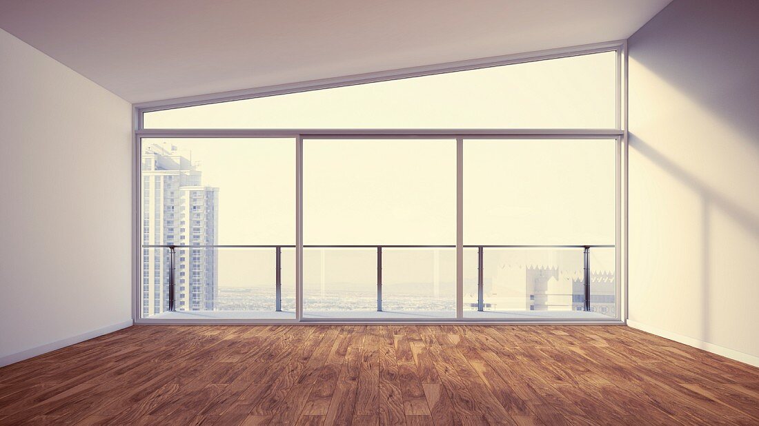 Empty apartment interior with sloping ceiling and glass wall with view of city