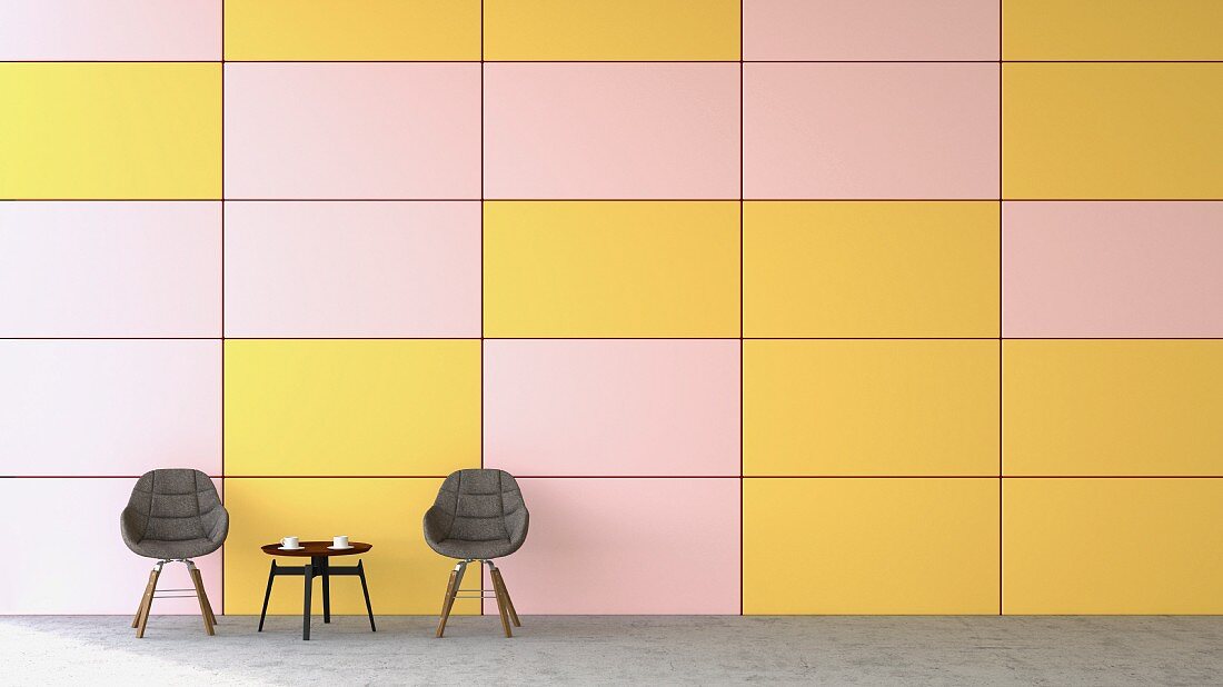 Waiting area with two chairs & coffee table against pink and yellow wall