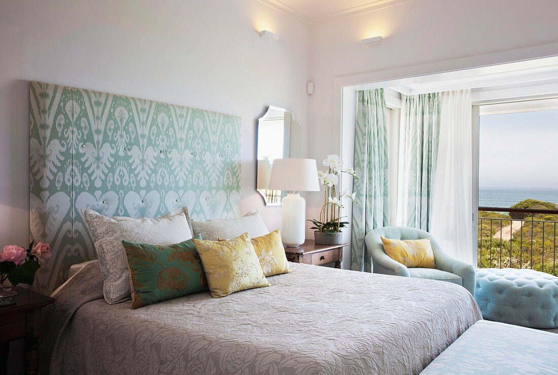 Schlafzimmer mit gepolstertem Bettkopfteil und Meerblick