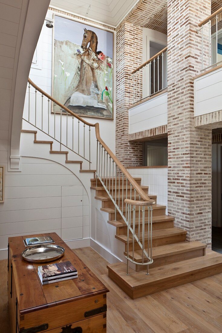 Elegant country-house-style stairwell with exposed brick walls and gallery