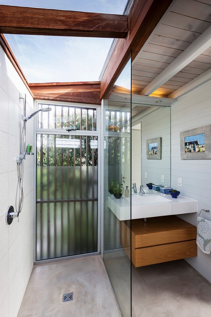Modern shower area with sink, skylights and wood-beamed ceiling