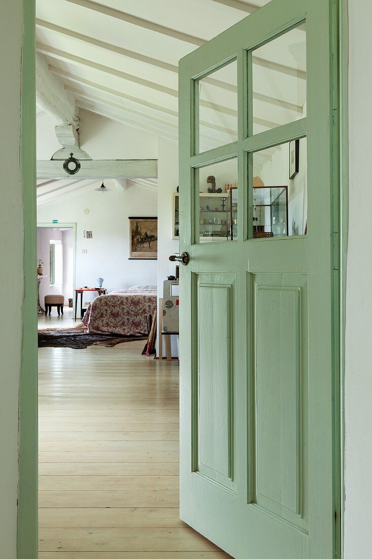 Pastellgrüne Zimmertür halboffen, Blick in Schlafbereich in offenem, ausgebautem Dachgeschoss