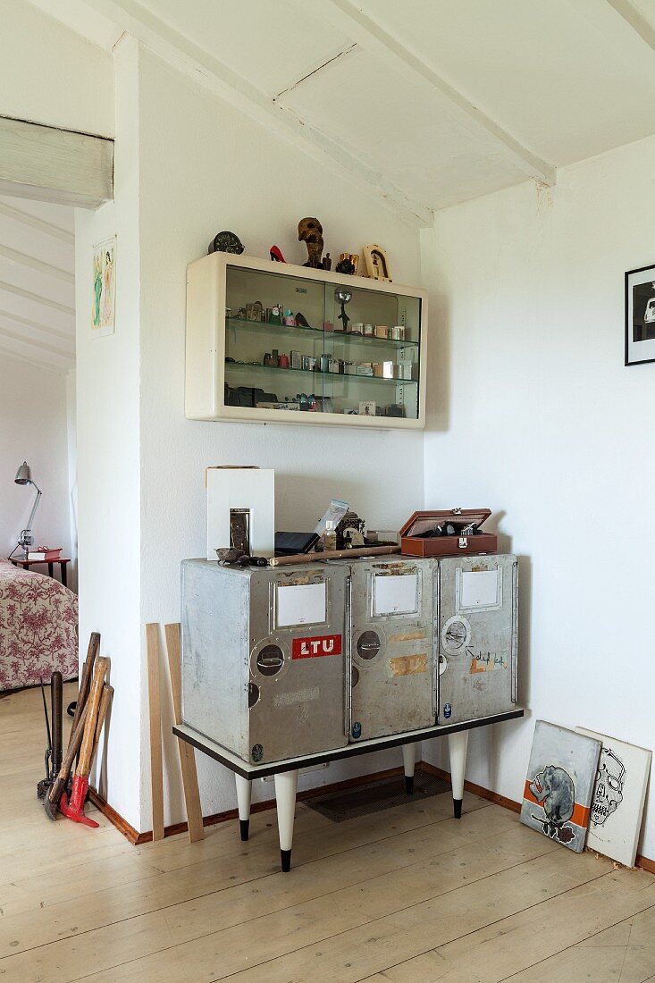 Upcycling-Sideboard in Zimmerecke unter Hängeschrank mit Feuerzeug-Sammlung