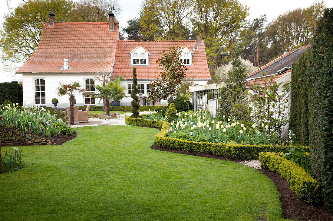 Haus mit gepflegtem Garten und Rasen