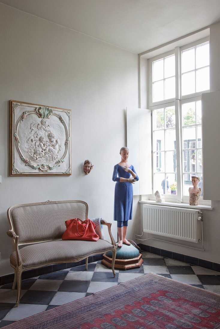 Dainty Rococo-style couch on chequered floor in artistic interior