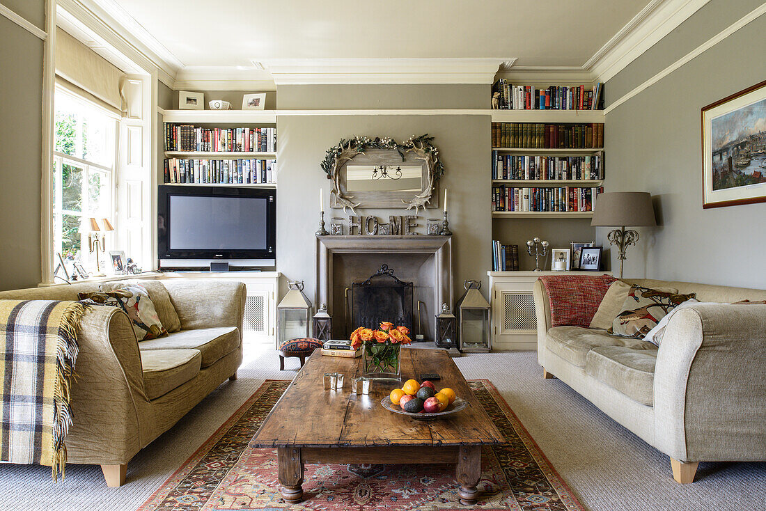 Sofas, rustic coffee table and log burner in pale grey living room