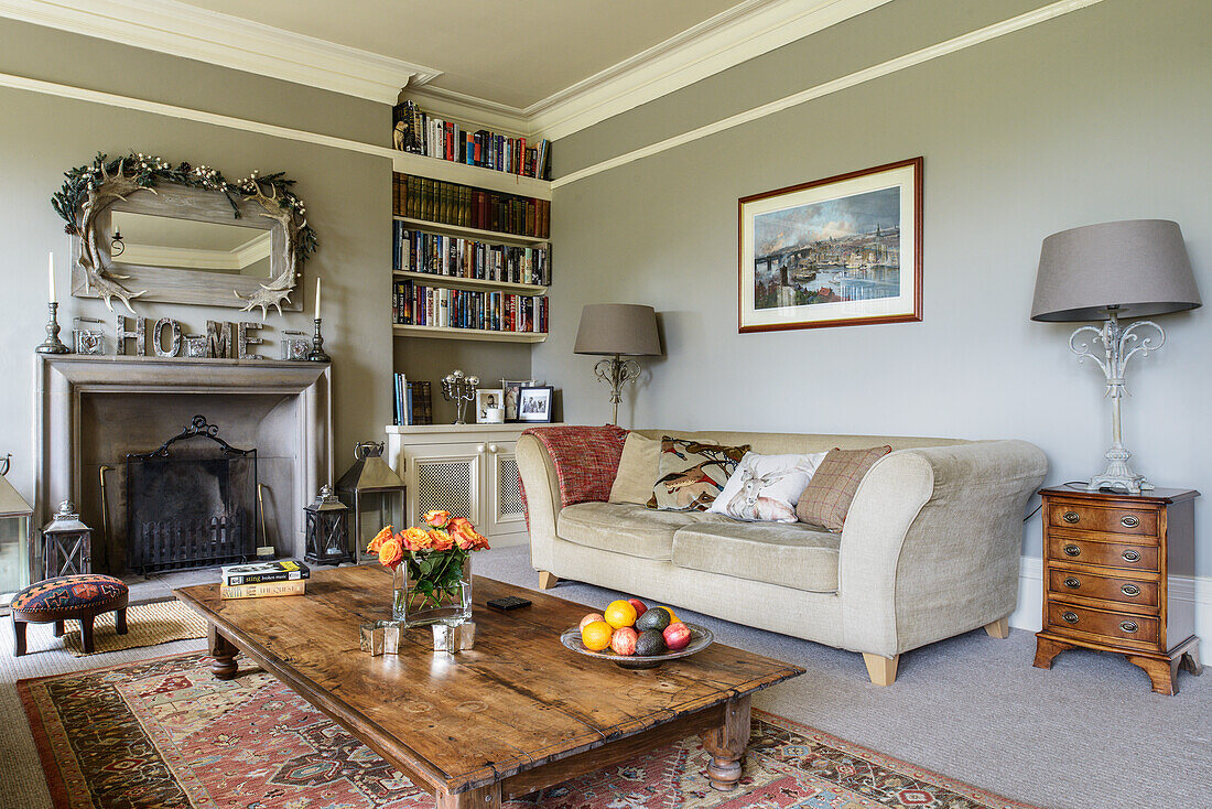 Sofa, rustic coffee table and log burner in pale grey living room