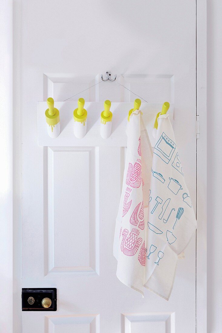 DIY pegs made from rolling pins on interior door