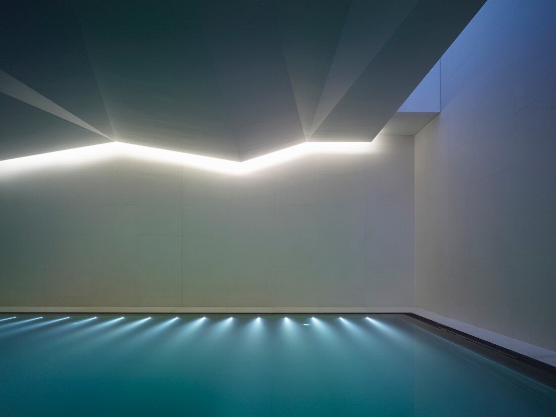Indoor Schwimmbad mit Unterwasserbeleuchtung, oberhalb indirekte Beleuchtung in gefalteter Decke