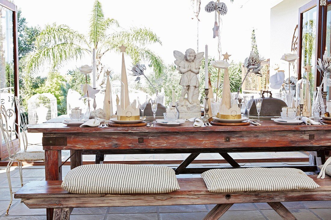 Dining table festively set with angel figurines in vintage-style interior