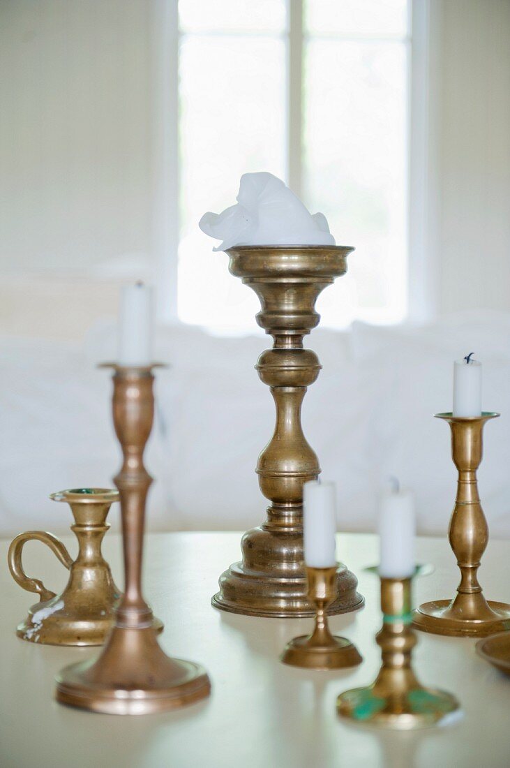 White candles in brass candlesticks