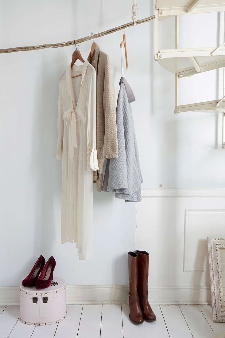 DIY clothes rail made from weathered branch in foyer