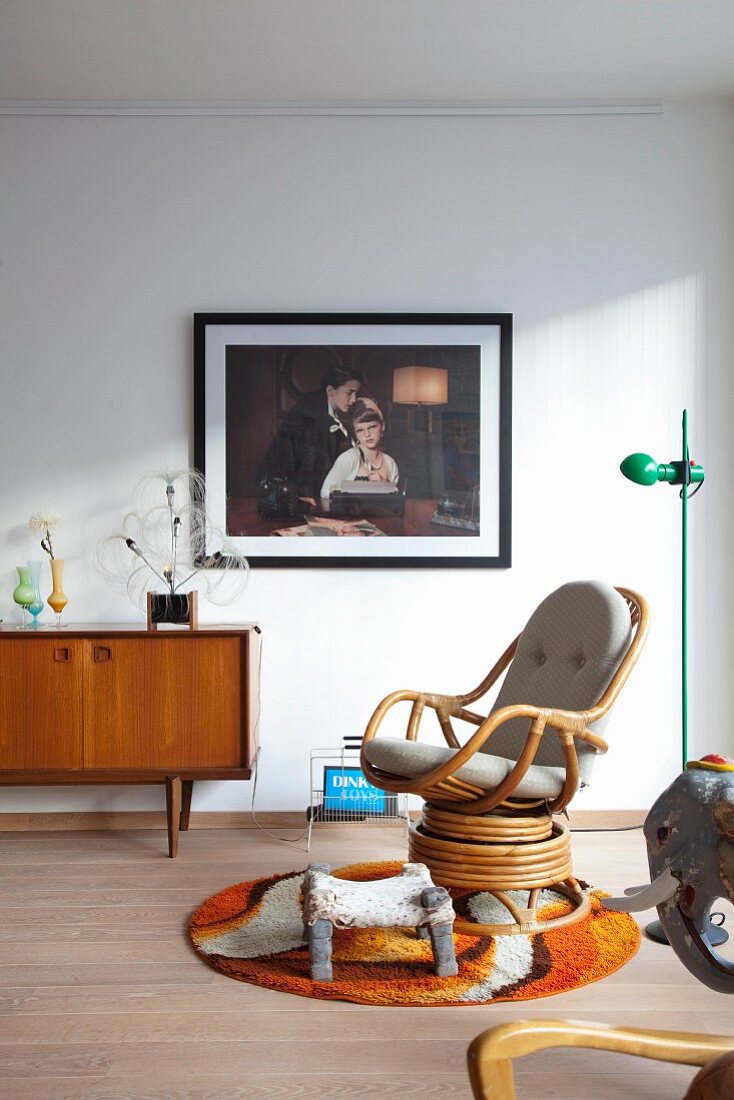 Rattan armchair on round 70s rug in retro living room