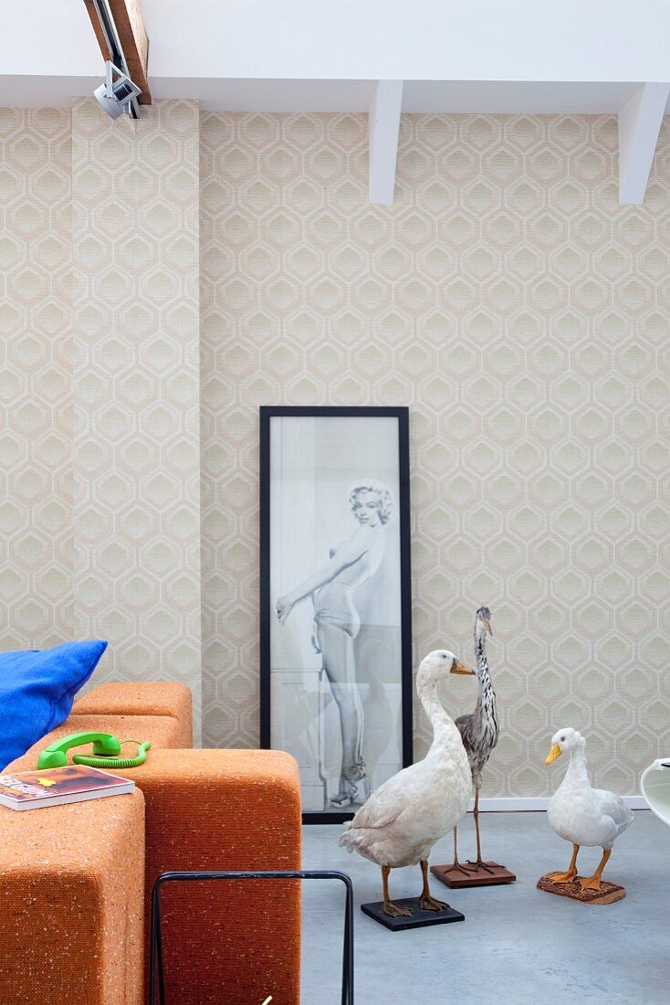 Unusual trio of stuffed birds in front of framed poster of pin-up girl