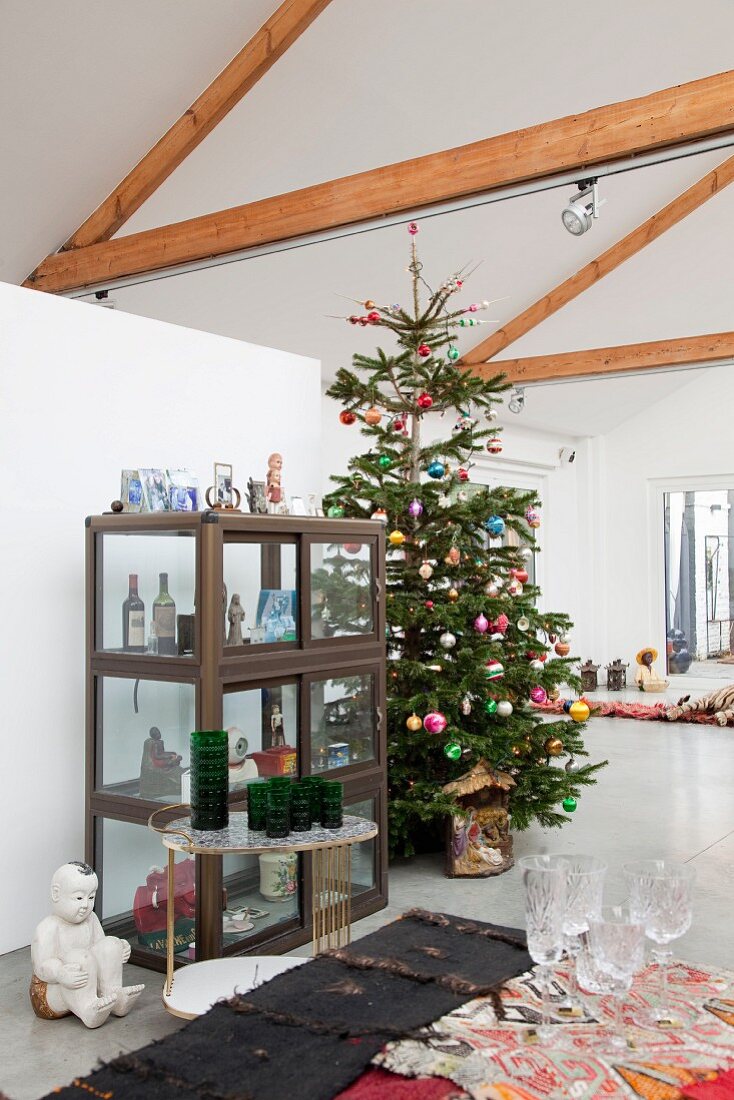 Christmas tree in loft apartment with exposed roof structure