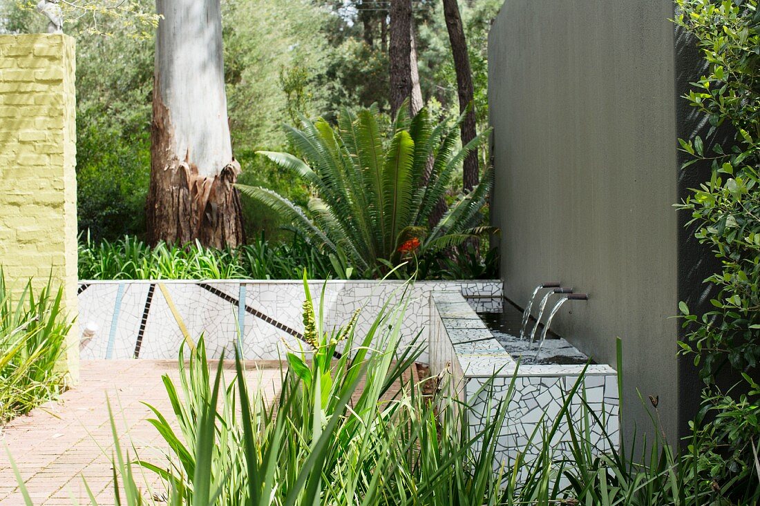 Gemauerter Brunnen mit Fliesenmosaik im Garten