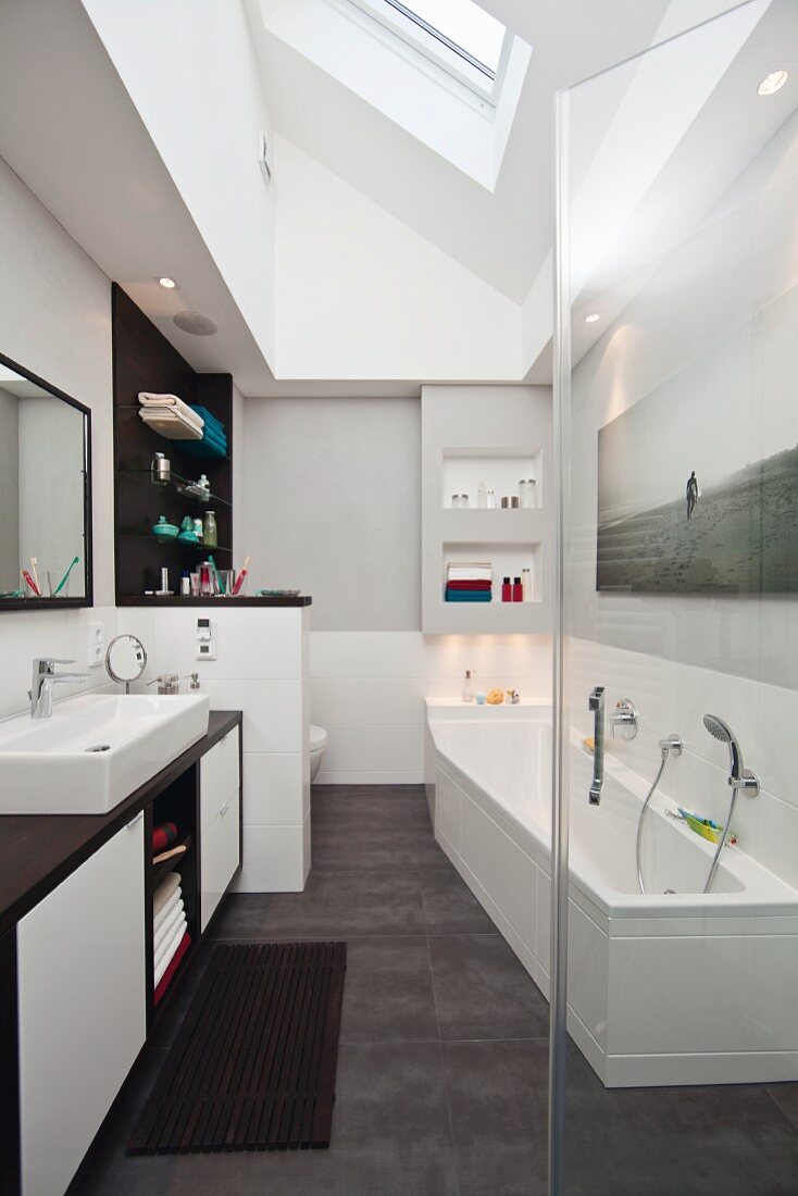 Renoviertes Badezimmer mit Waschtischzeile und eingebauter Badewanne unter Dachflächenfenster