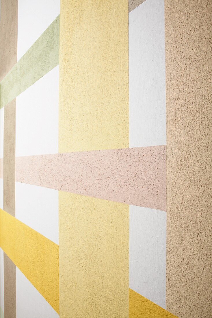 Wand mit verschiedenfarbigen Streifen aus Streichputz im Lagenlook