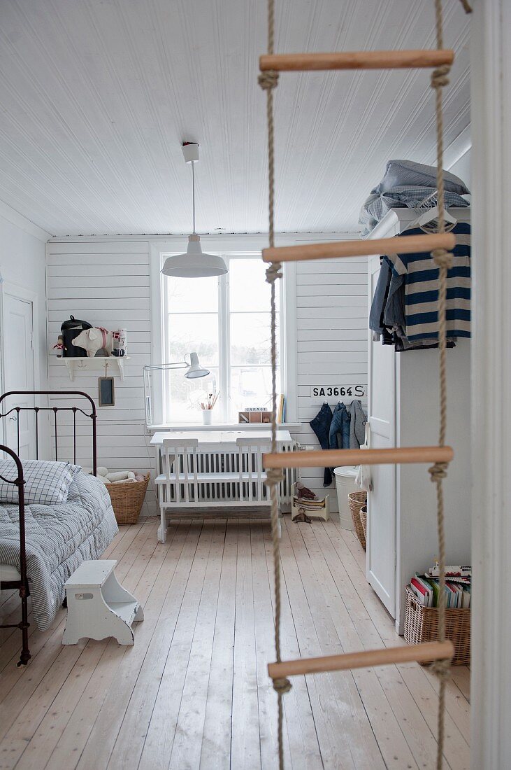 View into vintage-style child's bedroom through rope ladder
