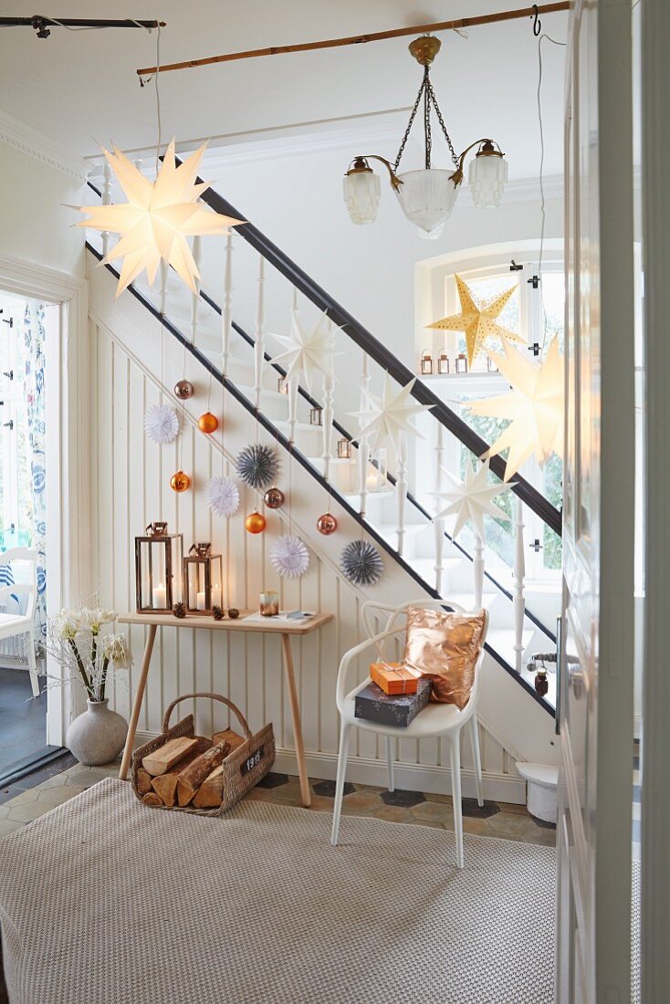 A hallway decorated with paper stars and Christmas baubles