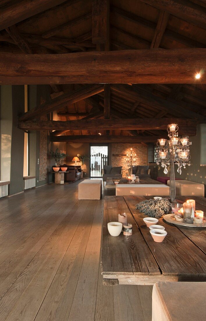 Wohnraum mit sichtbarer Holzkonstruktion, Couchtisch mit Platte aus Holzbrettern und Polsterbänke