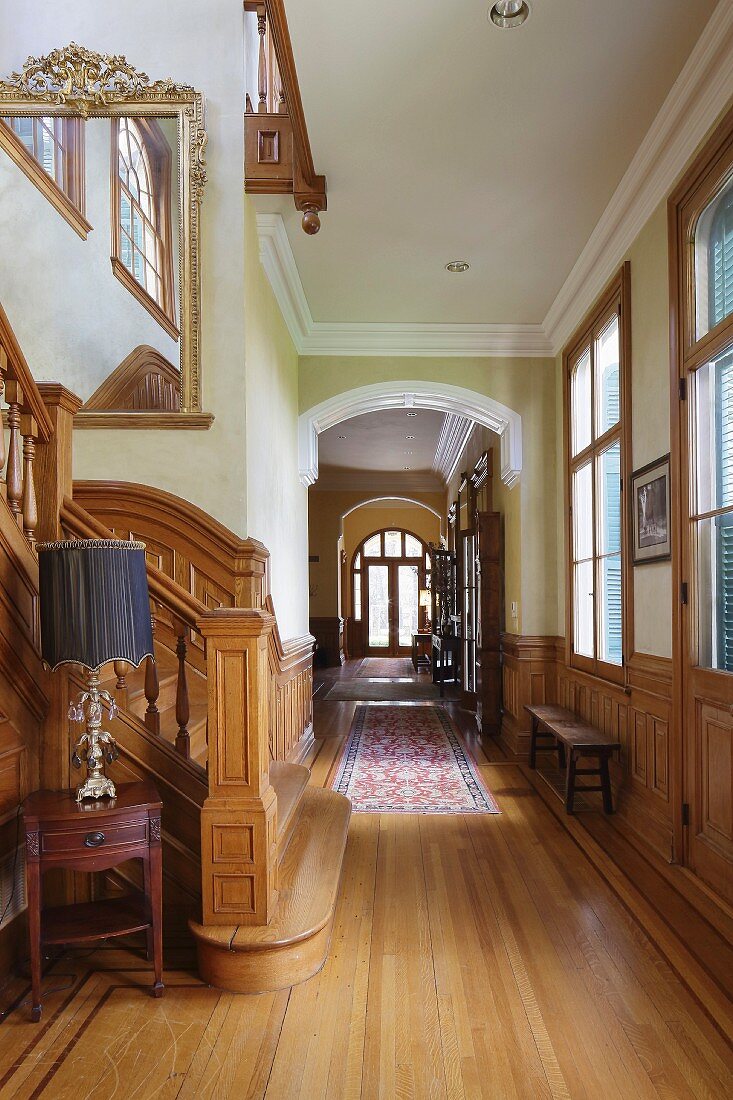 Treppenhaus und langer Gangbereich mit halbhoher Holzverkleidung und Schnitzereien in eleganter Villa