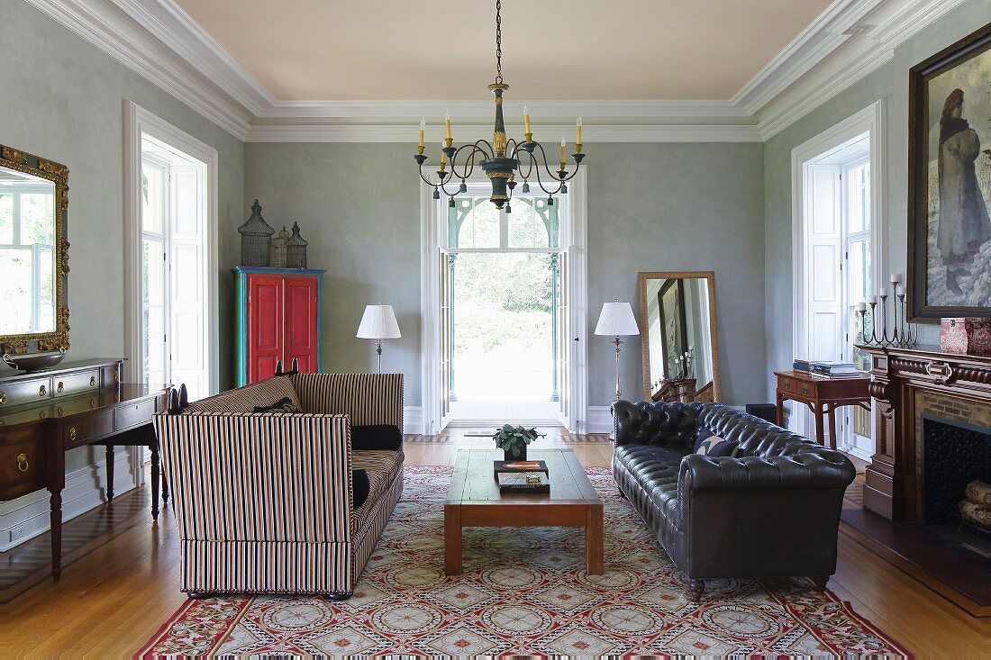 Sofa mit hoher Lehne und Streifenbezug und klassischem Ledersofa im Salon
