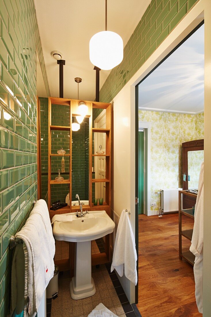 Schmaler Badbereich, mit grünen Retro Fliesen hinter geöffneten Schiebetüren, Blick ins Schlafzimmer
