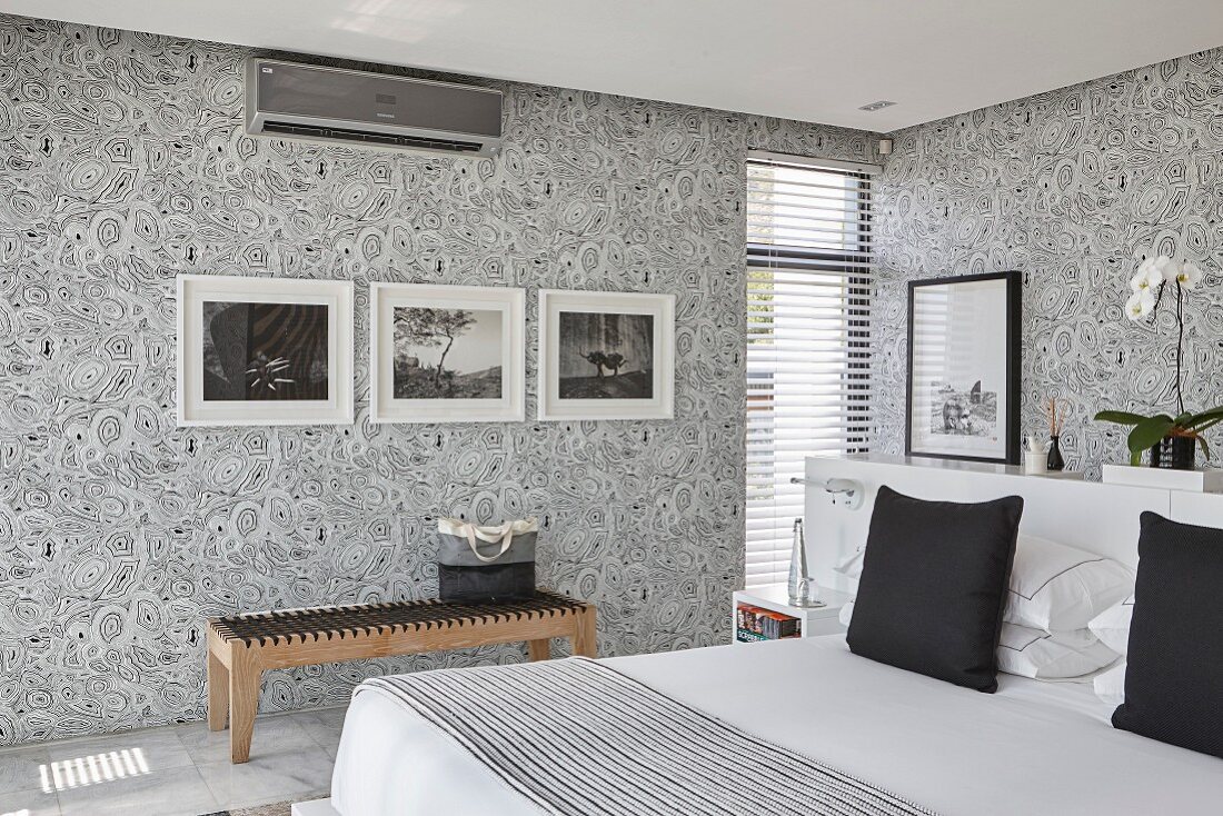 Elegantes Schlafzimmer mit Mustertapete und schwarz-weißem Farbkonzept