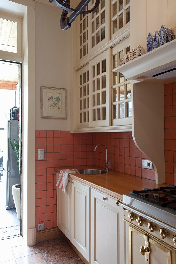 Kitchen counter with white base units and country-style wall units with lattice doors
