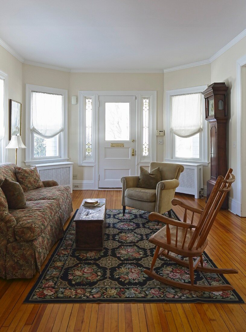 Traditional living room with bay window, rocking chair and armchair on floral rug