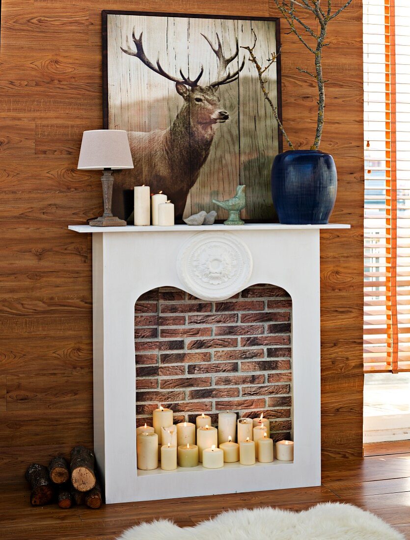 Lit pillar candles in DIY faux fireplace