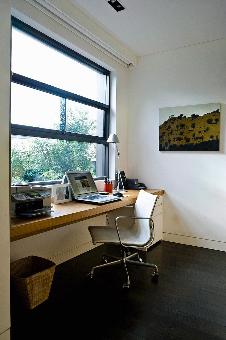 Arbeitszimmer mit Klassiker Bürostuhl vor Schreibtisch am Fenster