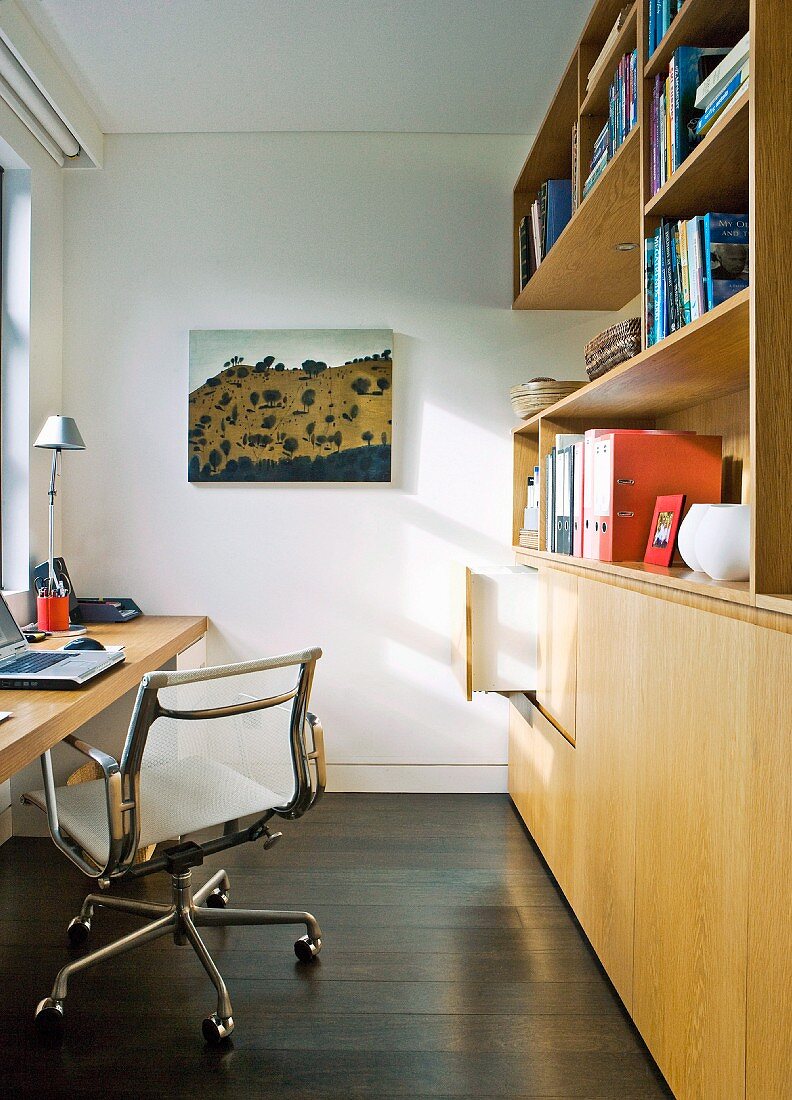 Schmales Arbeitszimmer mit Klassiker Bürostuhl vor Schreibtisch und Einbauschrank aus Holz