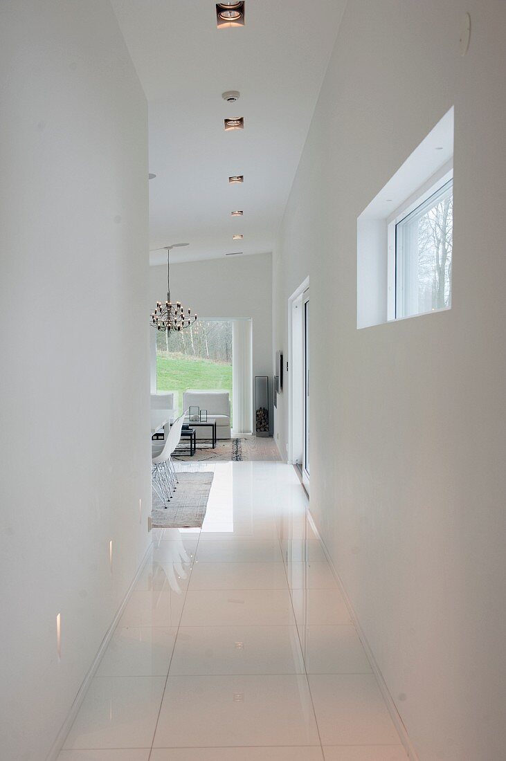 Schmaler Gangbereich mit weißem Fliesenboden, im Hintergrund Wohnbereich