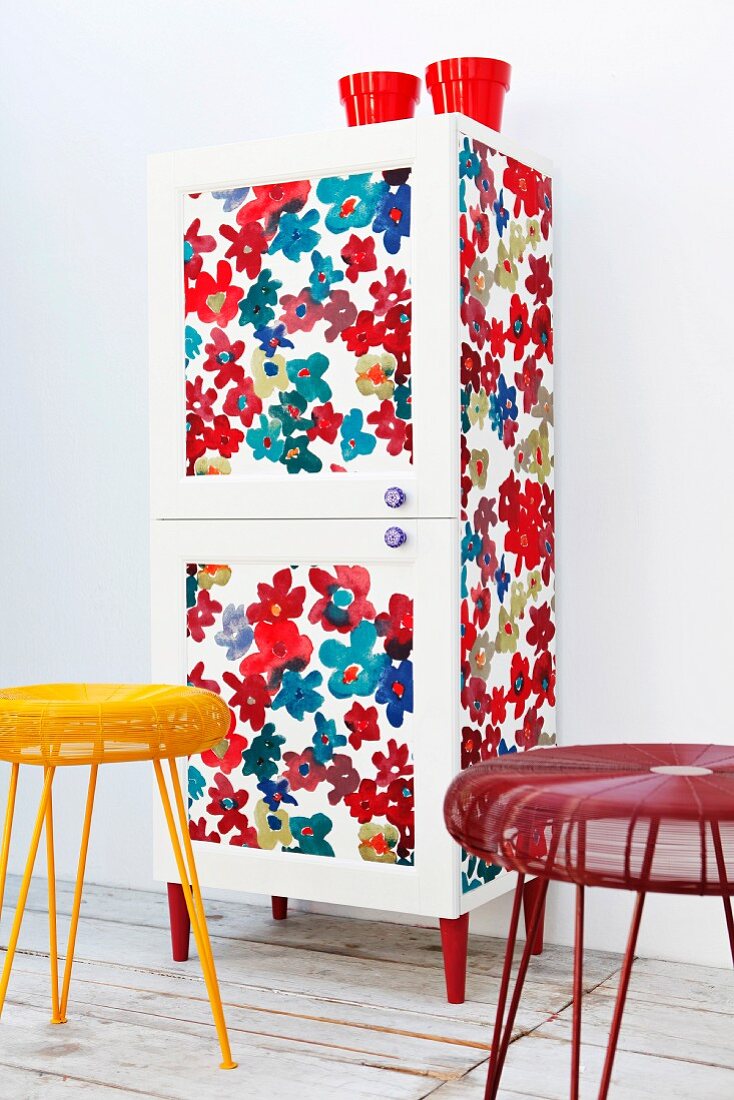 Wardrobe revamped with floral fabric, decorative knobs and red legs
