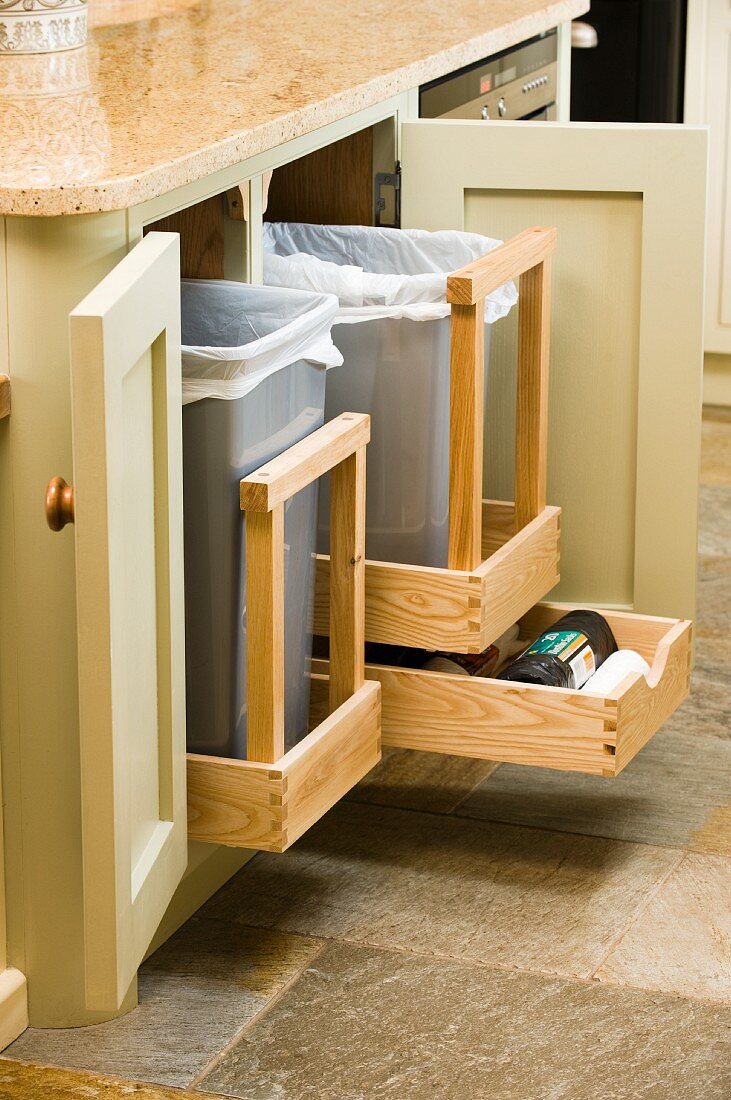 Open kitchen base units with waste bins on pull-out wooden racks