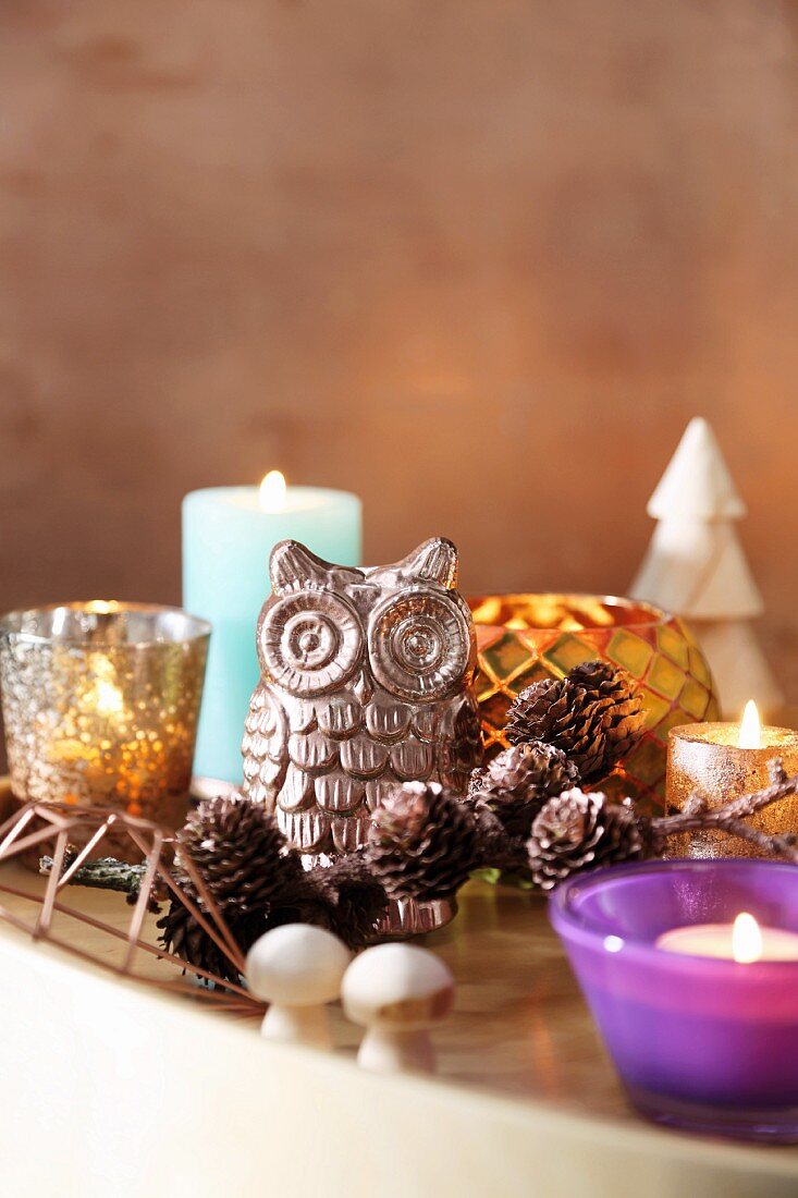 Owl ornament, larch cones, candles and tealight holders